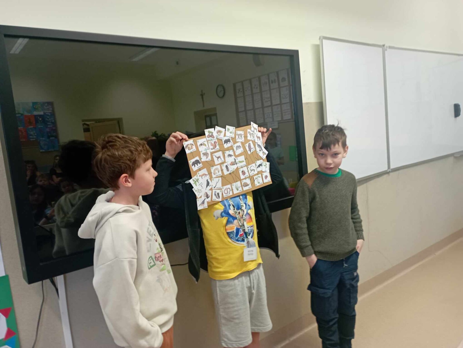 Uczniowie prezentują plakat z siecią pokarmową